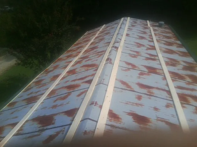 Rusted metal roof panels with new wood purlins before replacement — Storm Damage Roof Repair in Caldwell by Roofing Brothers