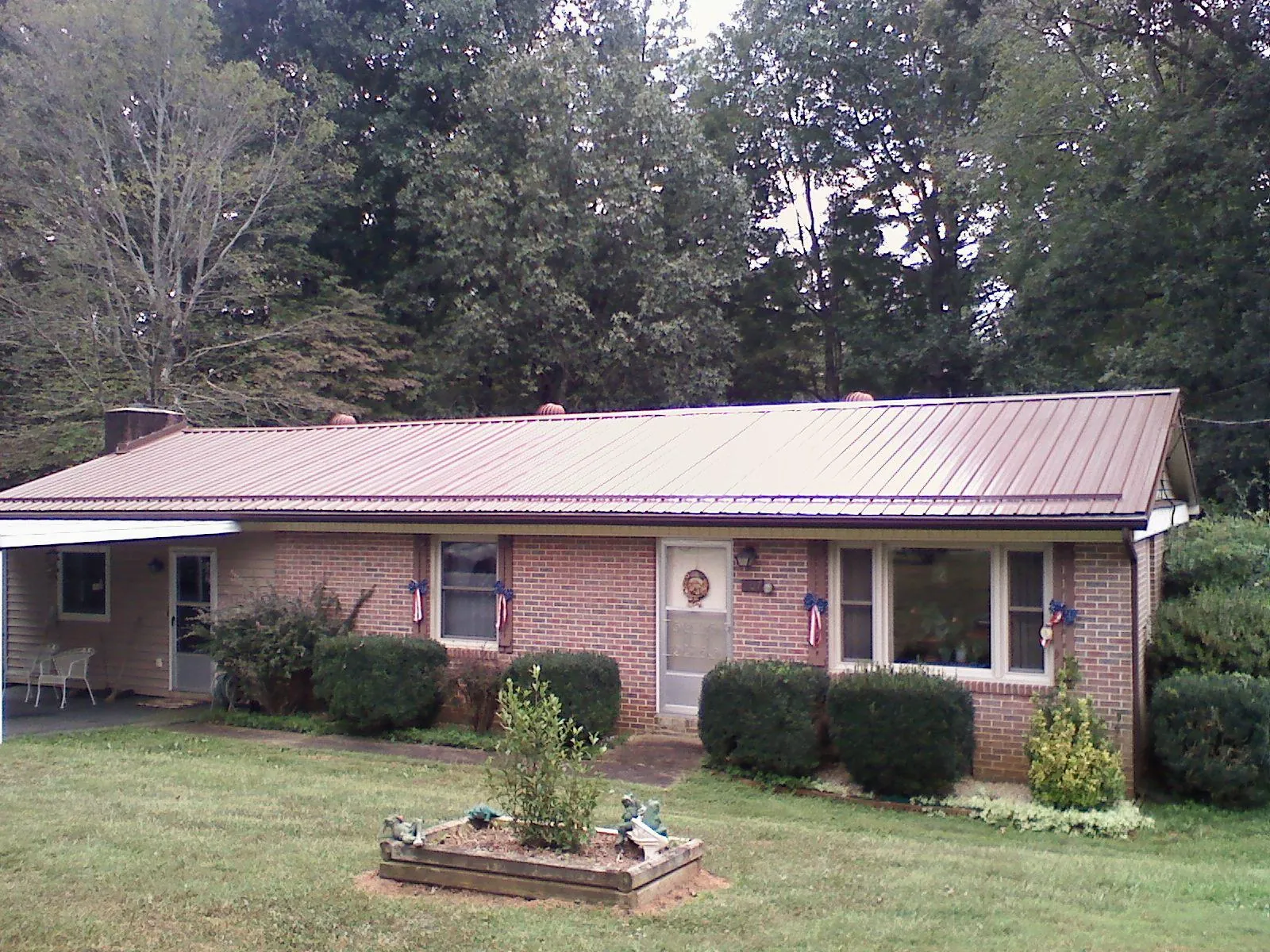 Bronze metal roof on a brick ranch home with a carport in Caldwell