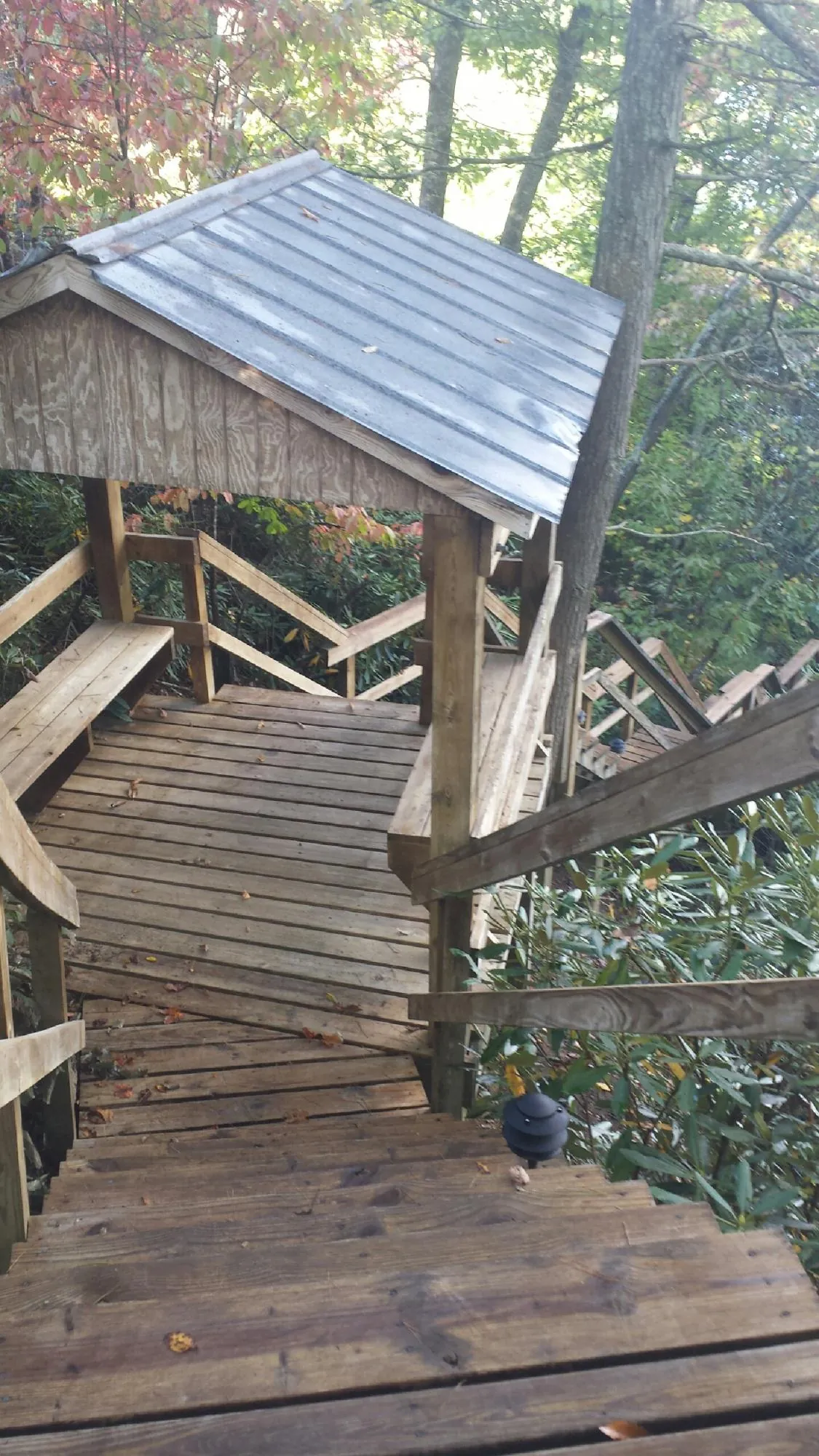Metal roofed shelter over wooden steps on a wooded walkway — Skylight Repair & Installation work by our crew in Caldwell