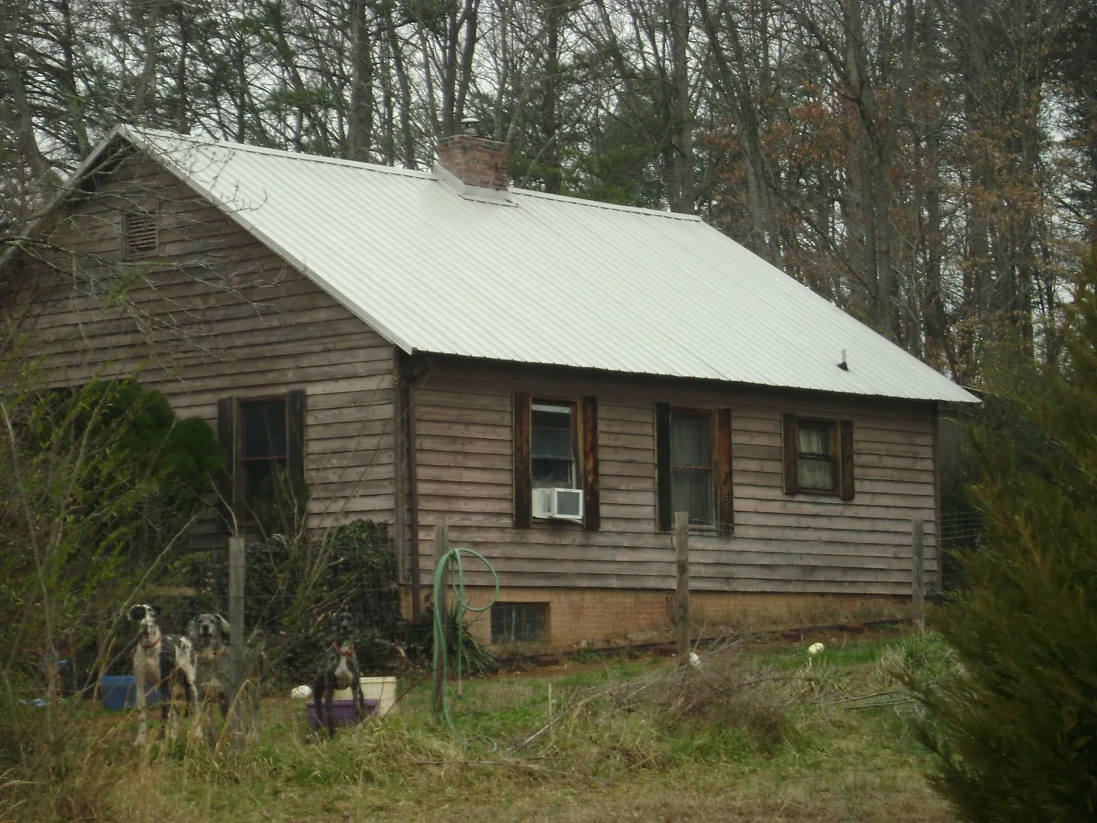 White metal roof on an old wood sided farmhouse, from a Metal Roof Installation job in Caldwell